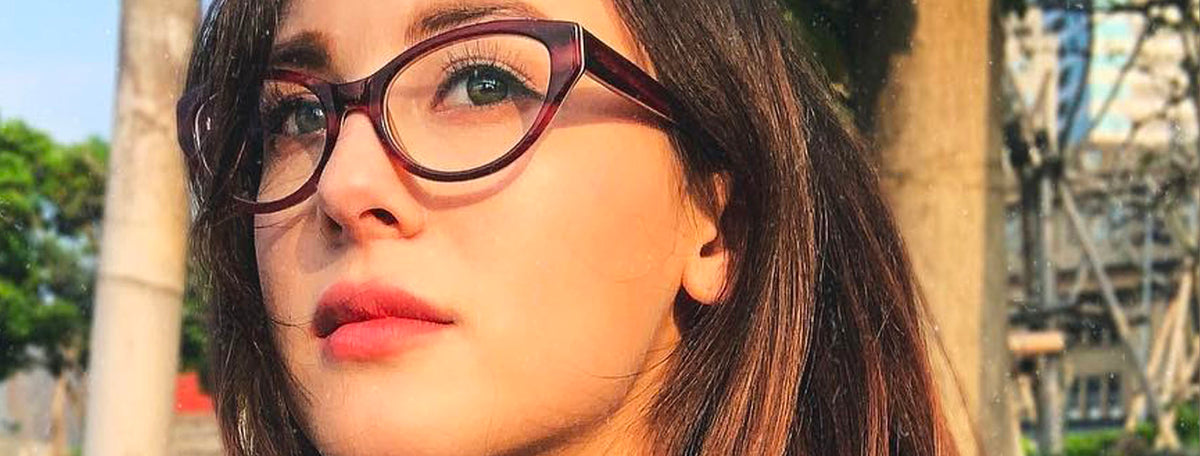 woman with long dark hair wearing cat eye eyeglasses frames